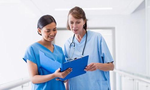 Nurse administrator reviewing patient charts with RN